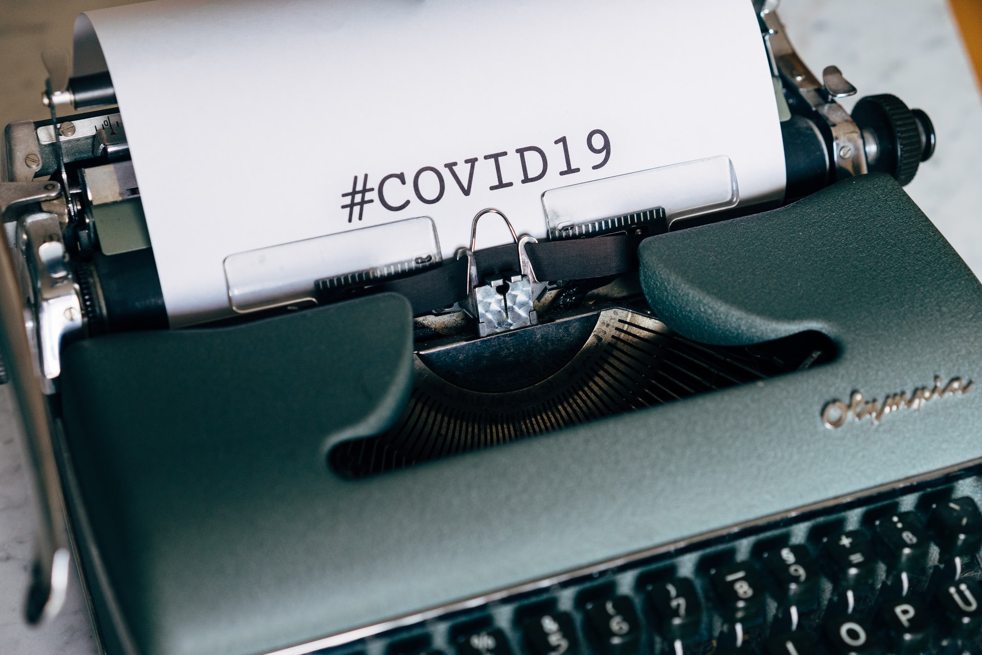 Typewriter paper displaying text: #COVID19