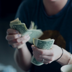 close up of person counting cash with their hands