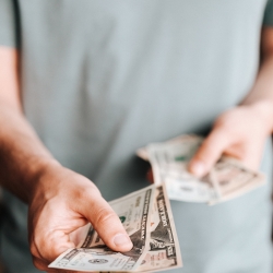 Man handing over 20 dollar bills